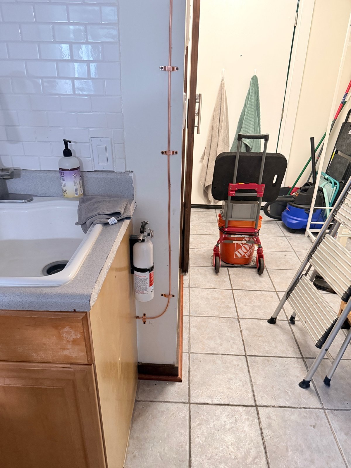 Documented copper piping installed and secured with clamps near a utility sink.