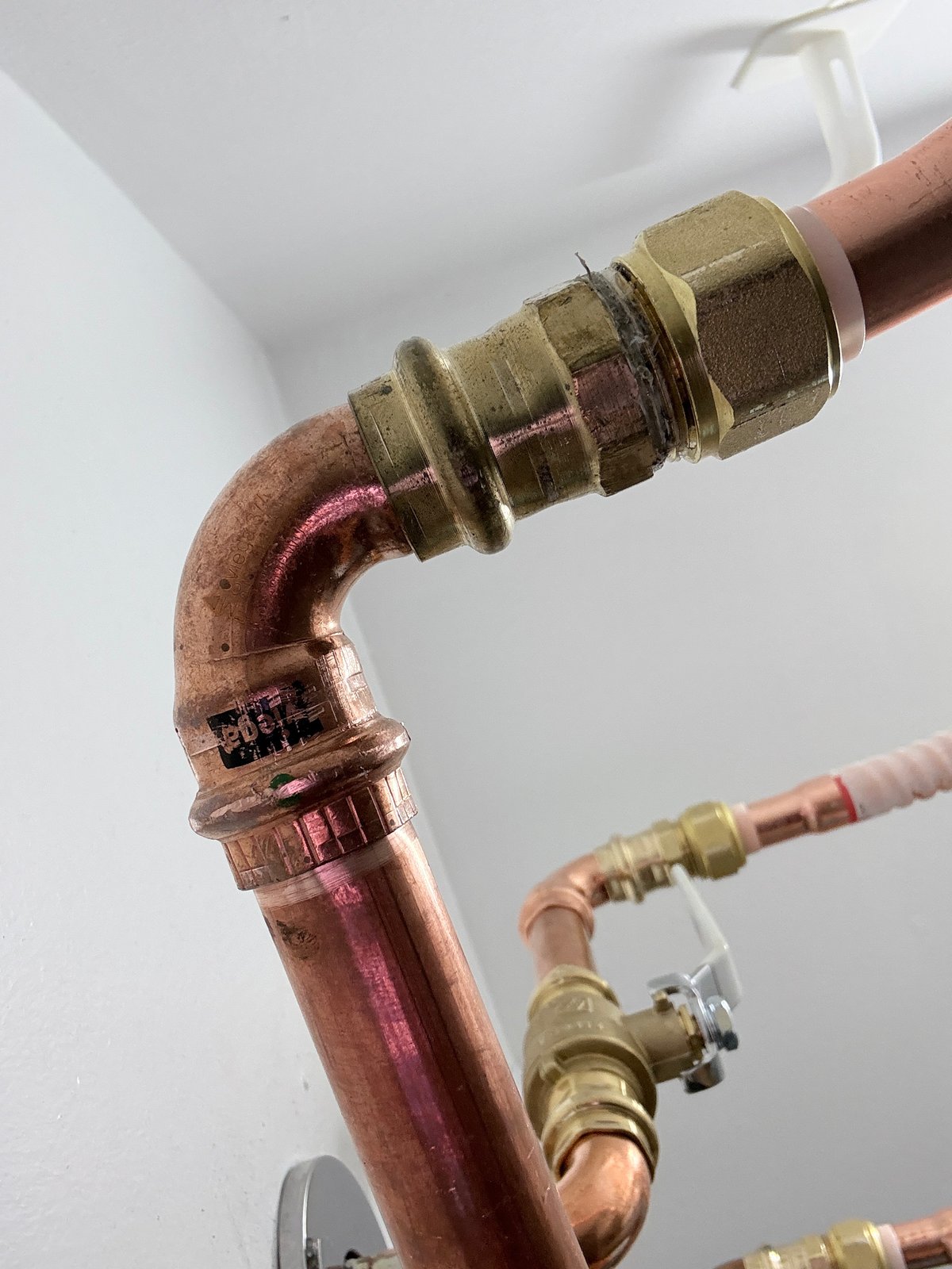 Documented copper water-line installation with a press-fit elbow and shut-off ball valve.