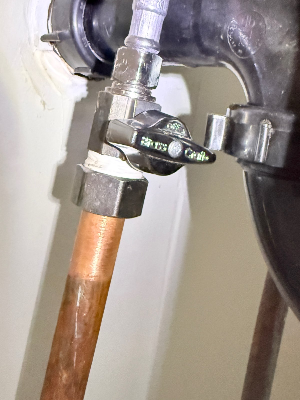Documented quarter-turn shut-off valve connected to copper piping and a flexible supply line.