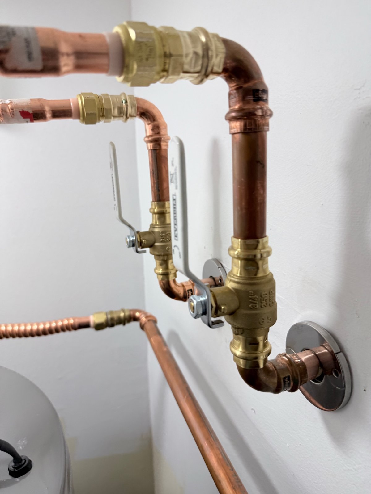 Documented copper water-heater piping with press-fit connections and brass shut-off valves.
